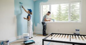 A couple paint their house bedroom