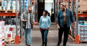 Warehouse team discussing materials for applying longest lasting exterior paint on exterior walls.